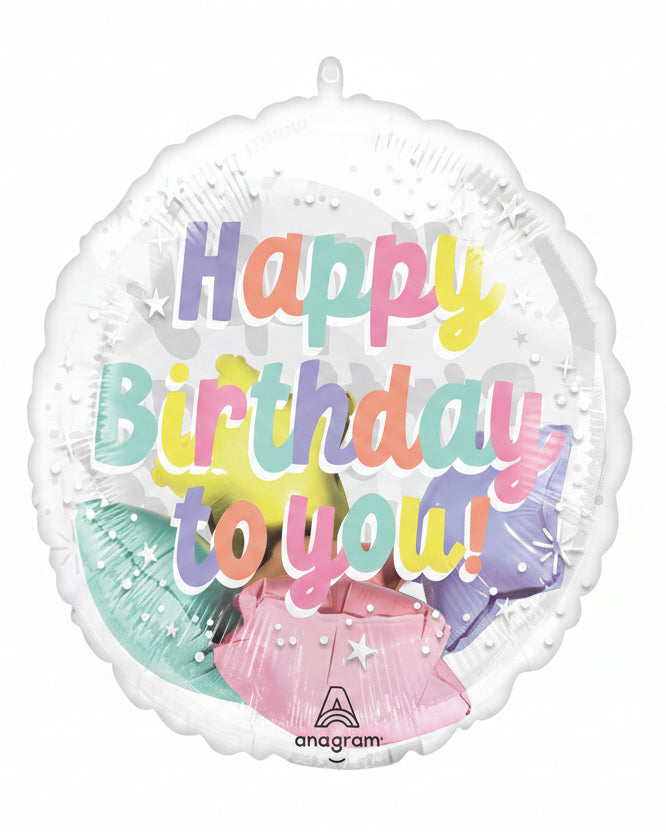 A round foil balloon with a scalloped edge, featuring the text 'Happy Birthday to you!' in pastel rainbow letters over a pastel illustration of a teapot, stars, and flowers. The brand name 'anagram' is printed at the bottom.