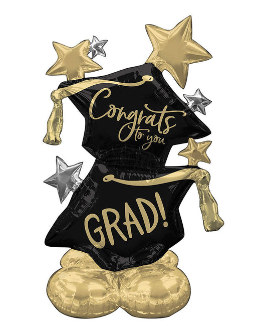 Graduation-themed balloon with 'Congrats to you' and 'GRAD!' text, black cap, gold tassel, and stars on a white background.