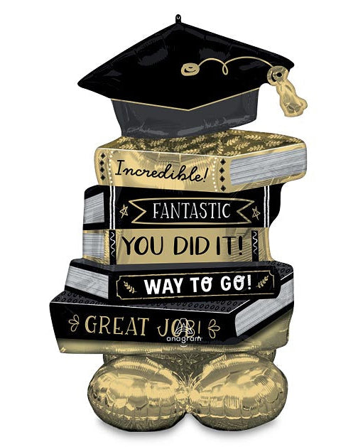 Graduation-themed decorative item with books and a cap on a white background