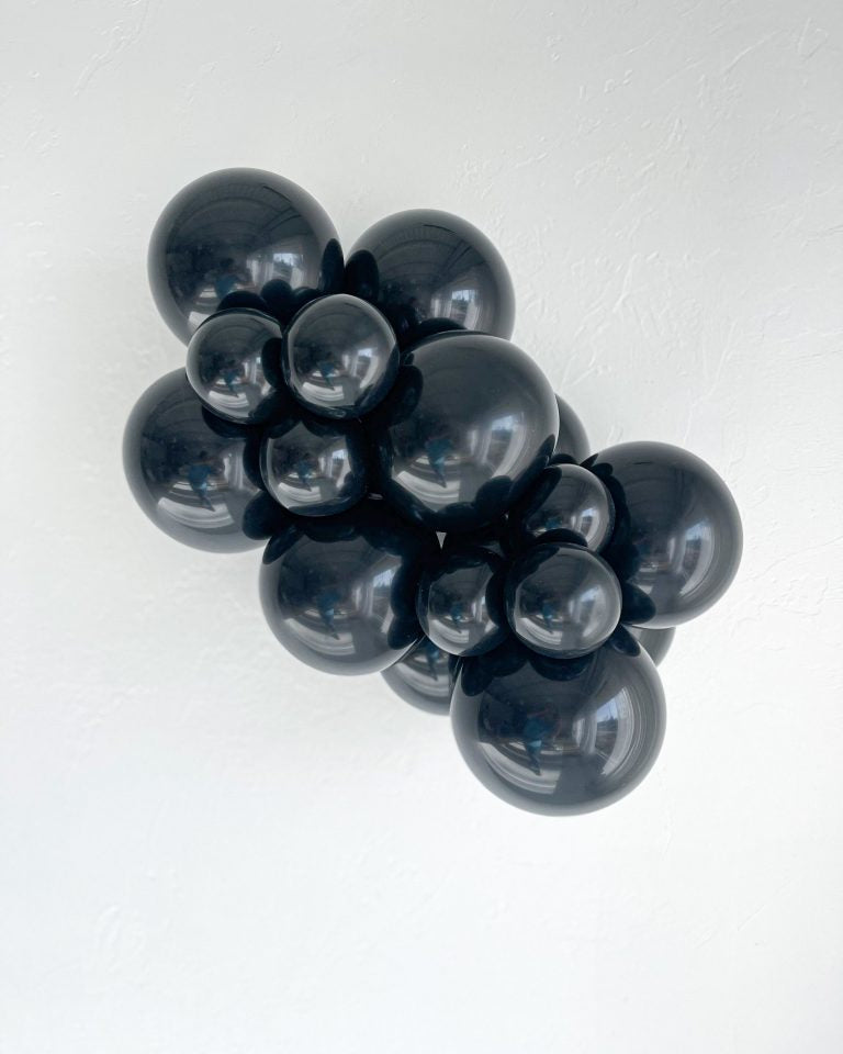 Cluster of black balloons on a white background