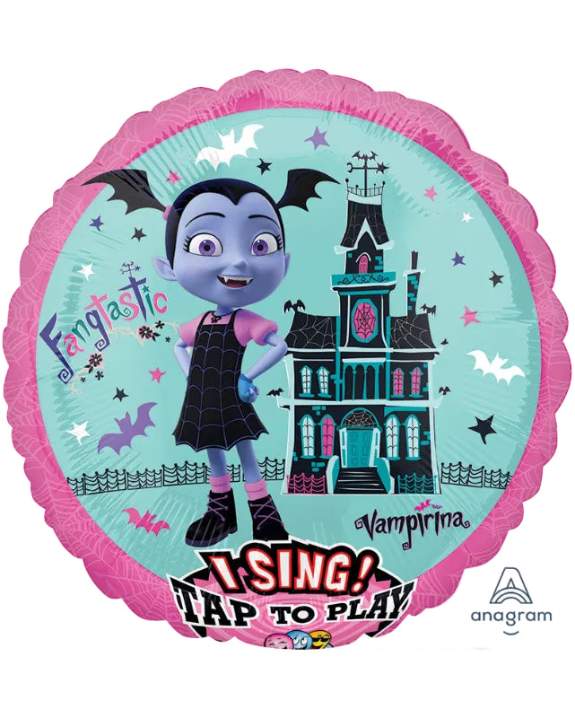 A round foil balloon featuring a Halloween-themed cartoon design with the character Vampirina, a haunted house, bats, stars, and the text 'I SING! TAP TO PLAY'. The balloon has a scalloped pink border and is shown on a plain white background.