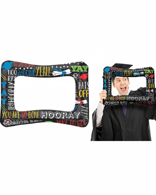 Graduation-themed photo frame with celebratory text held by a person in a graduation gown.