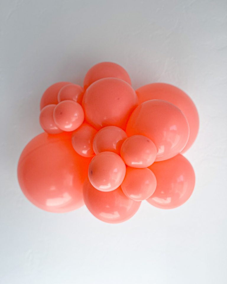 Cluster of coral balloons on a white background