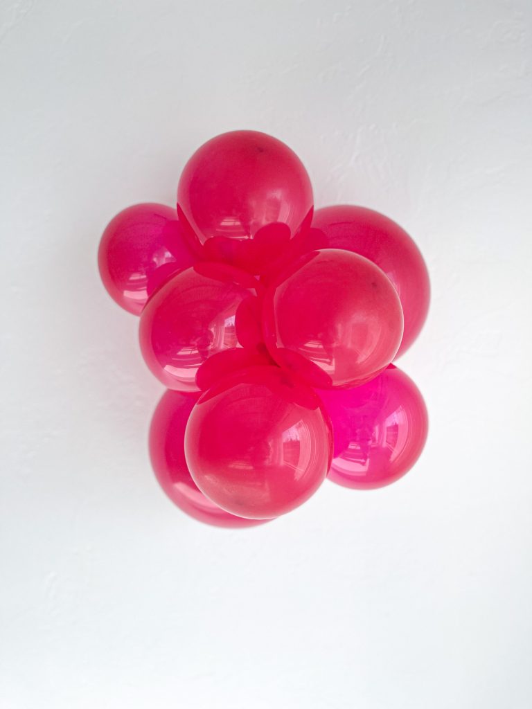 Cluster of magenta pink balloons on a white background