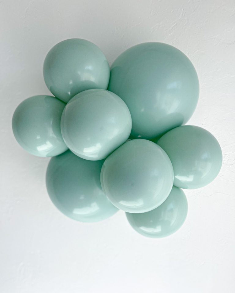 Group of mint green balloons on a white background
