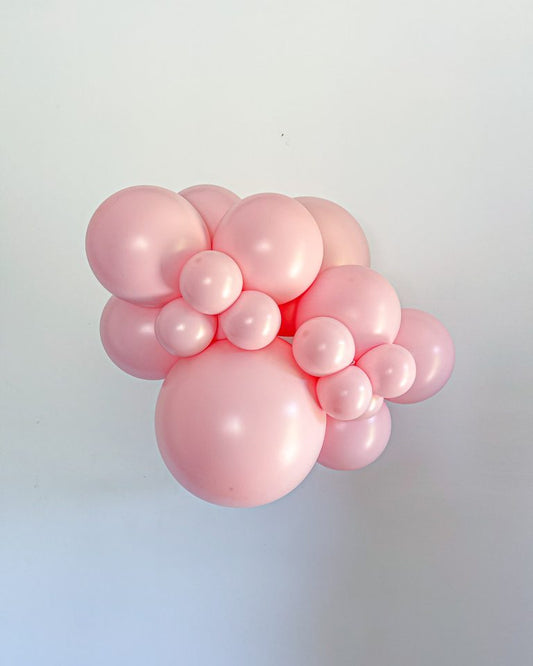 Cluster of pink balloons against a light gray background