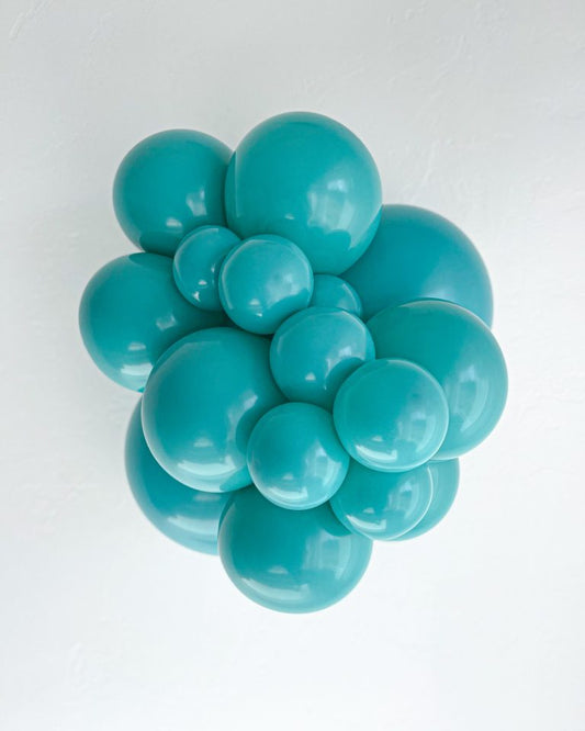 Turquoise balloon sculpture on a white background