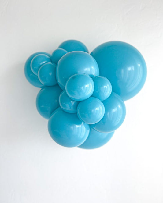 Balloon bunch of different sizes of turquoise colored balloons on a white background.