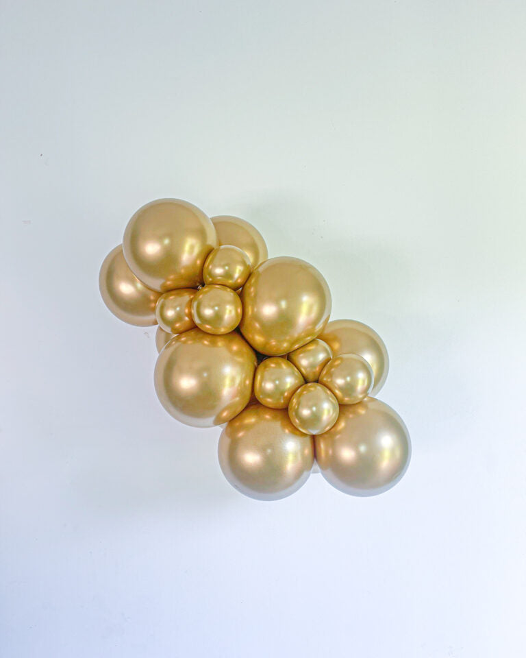 Cluster of gold balloons on a light blue background