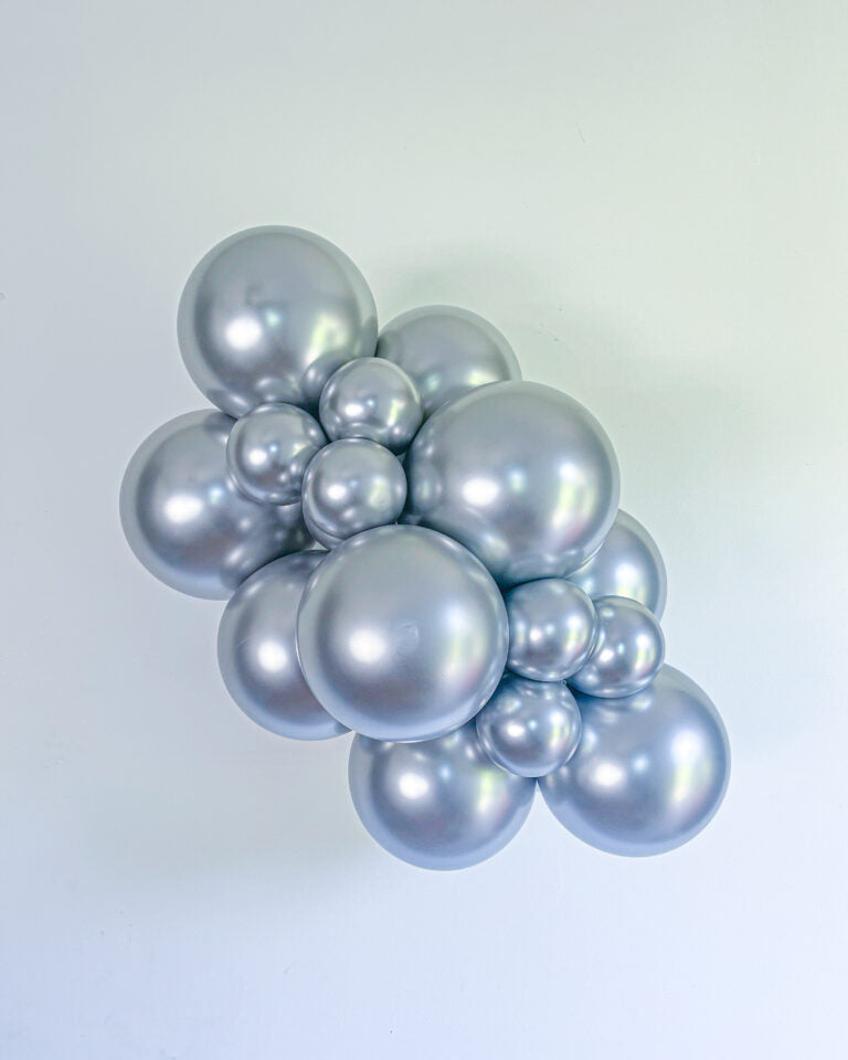 Cluster of silver balloons on a light gray background